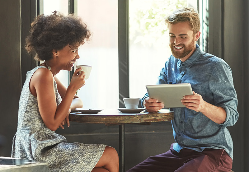 Cropped shot of a young couple using a digital tablet in a cafe